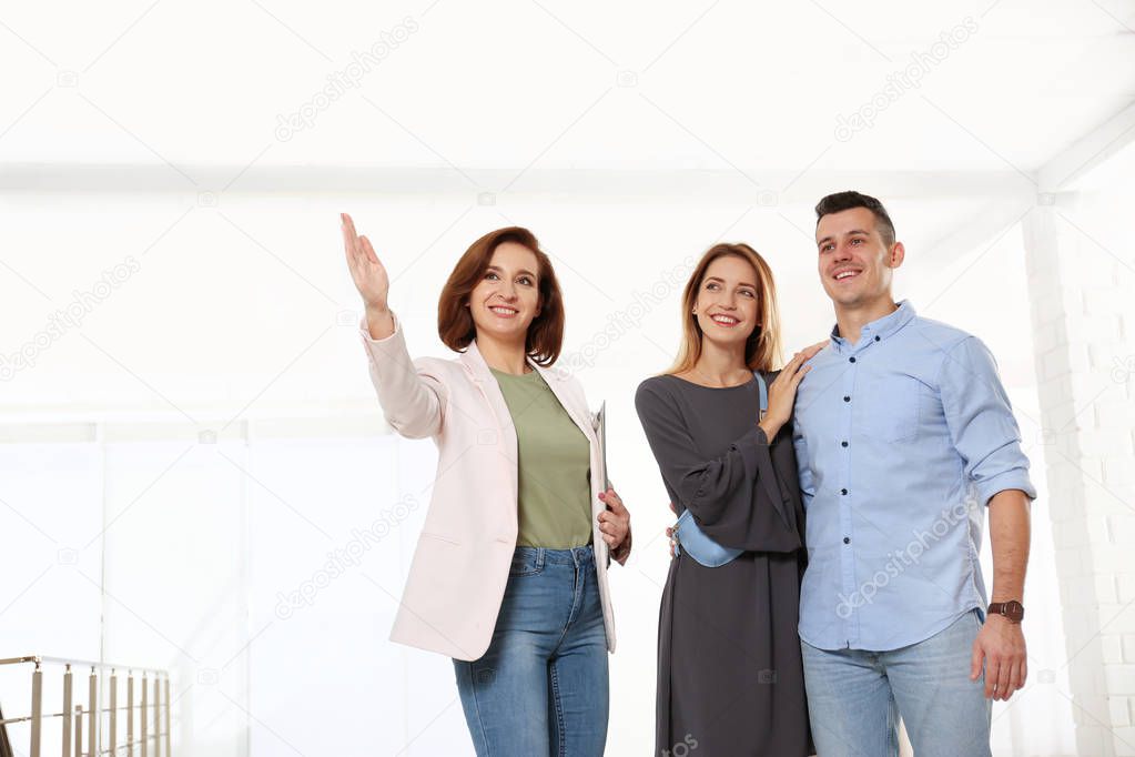 Real estate agent showing new apartment to young couple