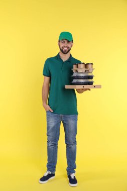 Genç kurye ile renk arka plan üzerinde farklı sipariş. Gıda dağıtım hizmeti