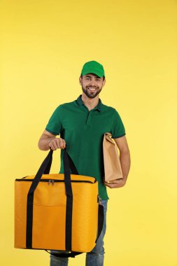 Genç kurye Termo TORBALI renk arka plan üzerinde. Gıda dağıtım hizmeti