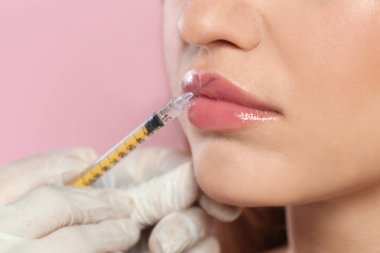 Genç kadın Dudak enjeksiyon renk arka planda, closeup alıyorum. Kozmetik cerrahi