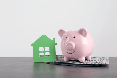 Kumbara oyuncak house beyaz arka plan yakınındaki dolarla