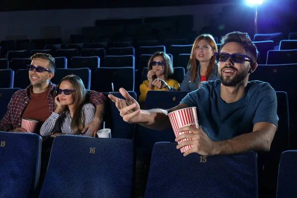 Young people watching movie in cinema theatre
