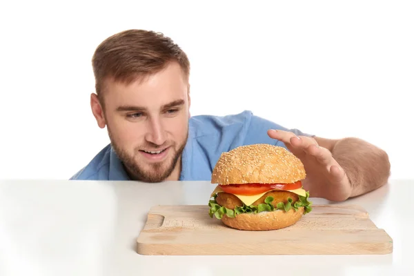 Young Man Eating Tasty Burger Color Background — Stock Photo, Image