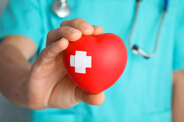 医生拿着红心与粘合剂石膏 特写镜头 心脏科概念 — 图库照片