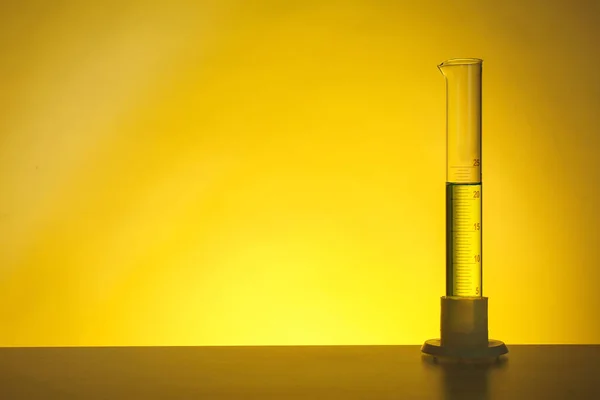 メスシリンダー液色背景にテーブルの上で 化学実験用ガラス器具 — ストック写真