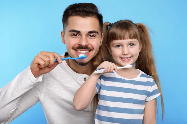 Kleines Mädchen Und Ihr Vater Beim Gemeinsamen Zähneputzen Auf Farbigem — Stockfoto