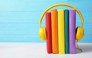 Masada ciltli kitaplar ile modern kulaklıklar. Metin için yer