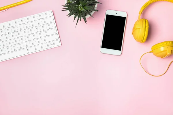 Flat lay composition with smartphone, computer keyboard and headphones on color background. Space for text