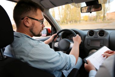 Mutlu bir adam açık havada kıdemli eğitmen ile tokalaşırken. Ehliyet almak