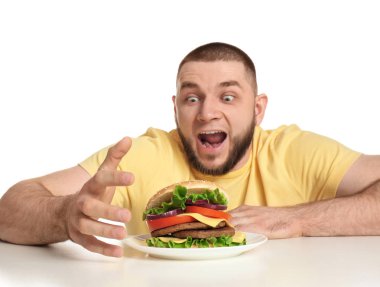 Genç aç adam ve beyaz zemin üzerine lezzetli burger