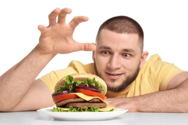 Genç adam ve beyaz zemin üzerine lezzetli burger