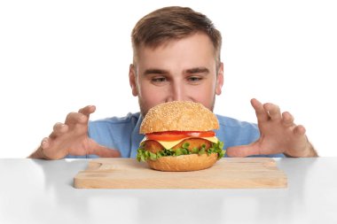 Genç adam ve beyaz zemin üzerine lezzetli burger