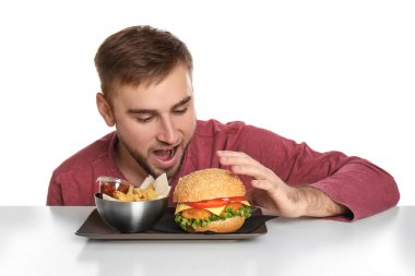 Genç adam ve kızarmış patates ve beyaz zemin üzerine lezzetli hamburger ile plakası