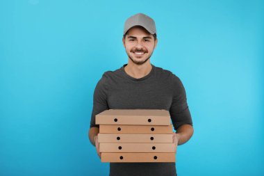 Genç kurye ile pizza kutuları renk arka plan üzerinde. Gıda dağıtım hizmeti