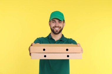 Genç kurye ile pizza kutuları renk arka plan üzerinde. Gıda dağıtım hizmeti