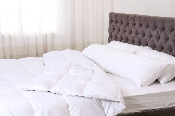 宽敞舒适的床 配有枕头和毯子 靠近室内窗户 时尚的内饰 — 图库照片