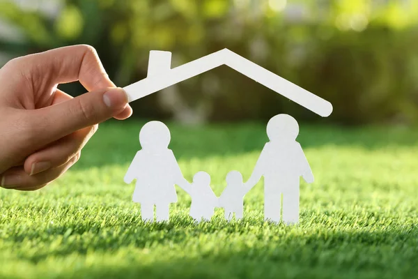 クローズ アップ 新鮮な草の上の家族の排気切替器で紙の屋根を持った女性 生命保険の概念 — ストック写真
