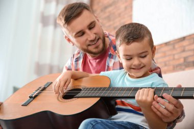 Baba evde gitar çalmayı küçük oğlu öğretim