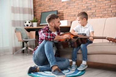Baba evde gitar çalmayı küçük oğlu öğretim