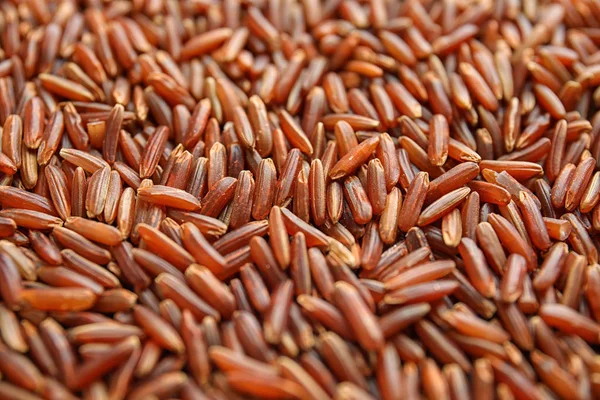Pile of uncooked red rice as background, closeup