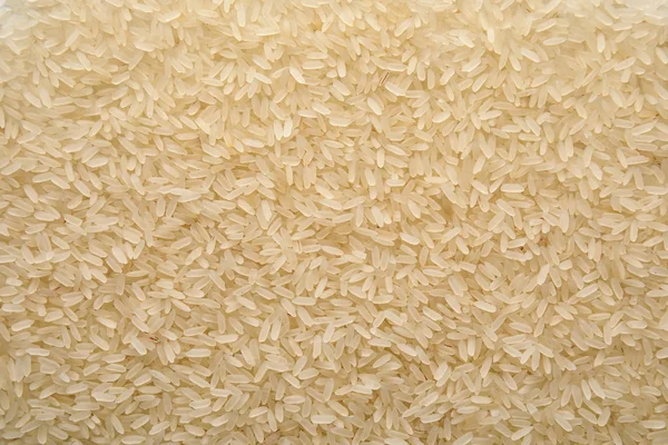 Pile of uncooked rice as background, top view