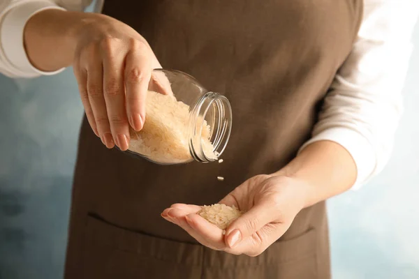 Mujer Vertiendo Arroz Sin Cocer Del Frasco Mano Sobre Fondo —  Fotos de Stock