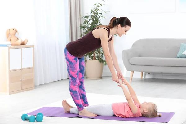 有运动的女人和女儿在家做健身练习 — 图库照片