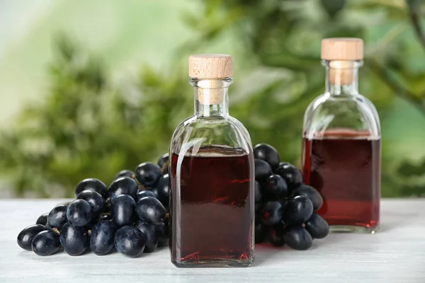 Bottles Wine Vinegar Fresh Grapes Wooden Table Blurred Background — Stock Photo, Image