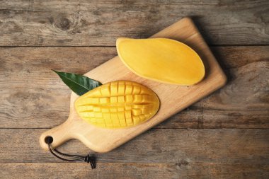 Ahşap arka plan üzerinde mango ile düz yatıyordu kompozisyon