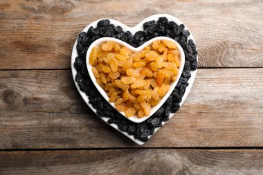 Düz yatıyordu kompozisyon ahşap zemin üzerine üzümlü. Kurutulmuş meyve sağlıklı çerez olarak