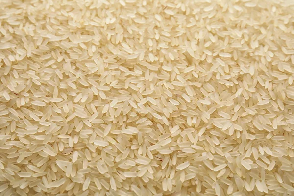 Pile of uncooked rice as background, closeup