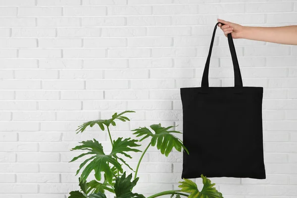 Kvinna Som Håller Eco Bag Nära Grön Växt Och Tegel — Stockfoto