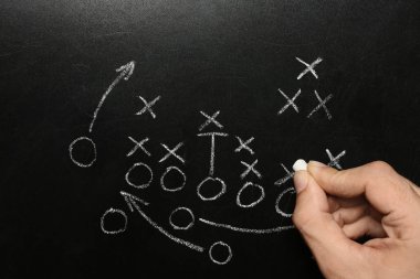 Man drawing football game scheme on chalkboard, top view clipart