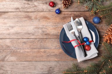 Noel tablo ayarını plaka ahşap arka plan, üstten görünüm üzerinde çatal bıçak takımı, peçete ile. Metin için yer