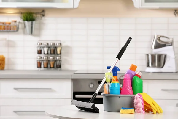 Set of cleaning supplies on table in kitchen. Space for text