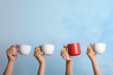 Diğerlerinden farklı Kupası renk arka plan üzerinde tutan kadın