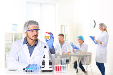 Laboratuvar, metin için yer tablosunda çalışan erkek bilim adamı. Araştırma ve analiz