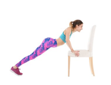 Beyaz arka plan üzerinde sandalye ile egzersiz genç kadın. Ev fitness