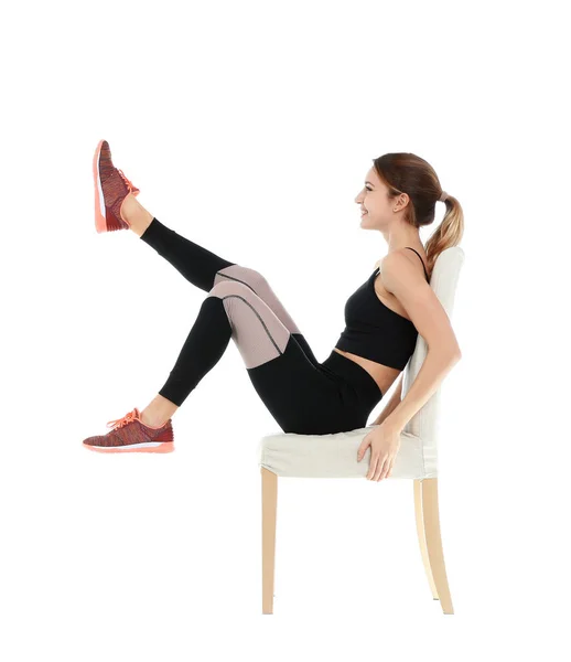 Young woman exercising with chair on white background. Home fitness