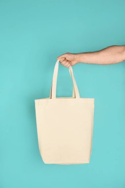 Holding adam alışveriş Eko çanta renk arka plan üzerinde pamuk. Mockup tasarım için