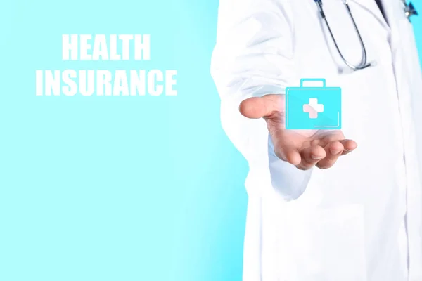背景色に対して応急キット アイコンを保持している医師 医療と健康保険の概念 — ストック写真