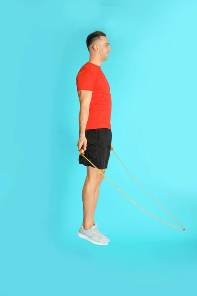 Jovem Esportivo Homem Treinamento Com Corda Salto Sobre Fundo Cor — Fotografia de Stock