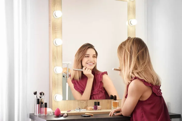 在更衣室用灯泡在镜子附近化妆的妇女 — 图库照片