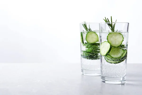 Glasses of fresh cucumber water on table. Space for text