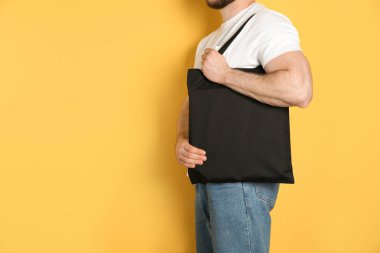 Eko çanta renk arka plan üzerinde alışveriş pamuk olan adam. Mockup tasarım için