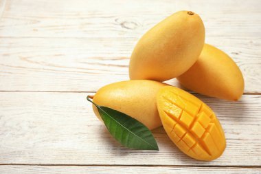 Ahşap arka plan üzerinde taze mango meyve ile kompozisyon. Metin için yer