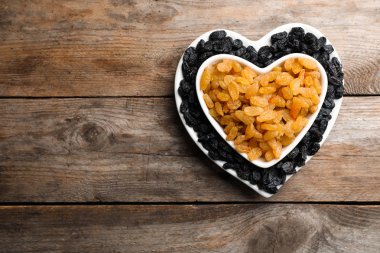 Kuru üzüm ve ahşap arka plan üzerinde metin için yer düz yatıyordu kompozisyonu. Kurutulmuş meyve sağlıklı çerez olarak