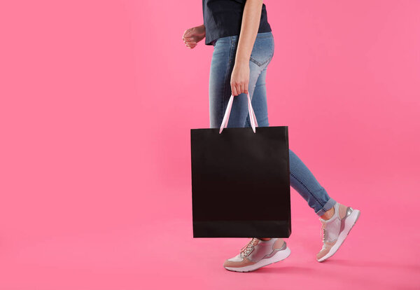 Woman with paper shopping bag on color background. Mock up for design