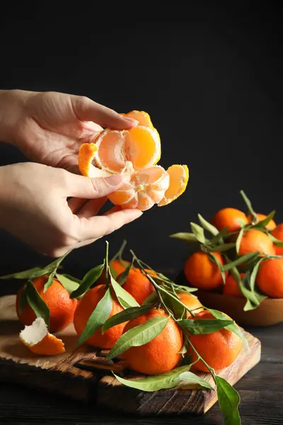 Frau Schält Reife Mandarine Über Tisch Auf Dunklem Hintergrund Nahaufnahme — Stockfoto