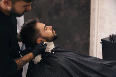 Profesyonel kuaför berber dükkanı tıraş sonra müşterinin cilt yatıştırmaya soğuk havlu kullanarak